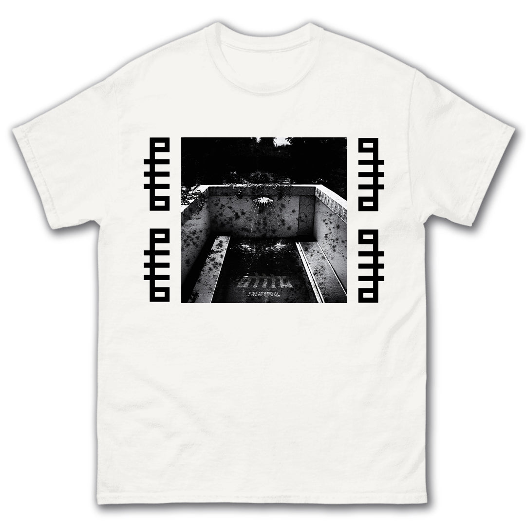 The OTTTO Sweaty Pool White T-Shirt features a black-and-white photo of an empty, graffiti-covered pool, bordered by black geometric patterns. Centered design. Available now for presale.